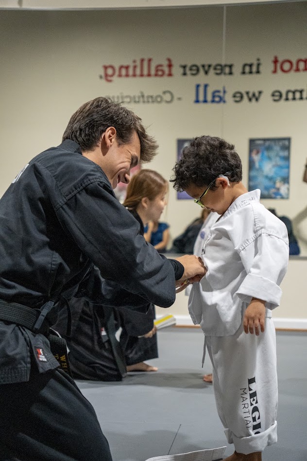 Instructor tying a Tiny Tigers student's belt
